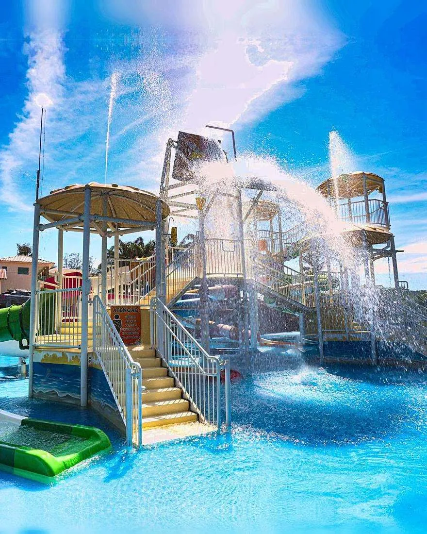 Torre de brinquedos aquáticos do parque com água caindo e céu azul ao fundo